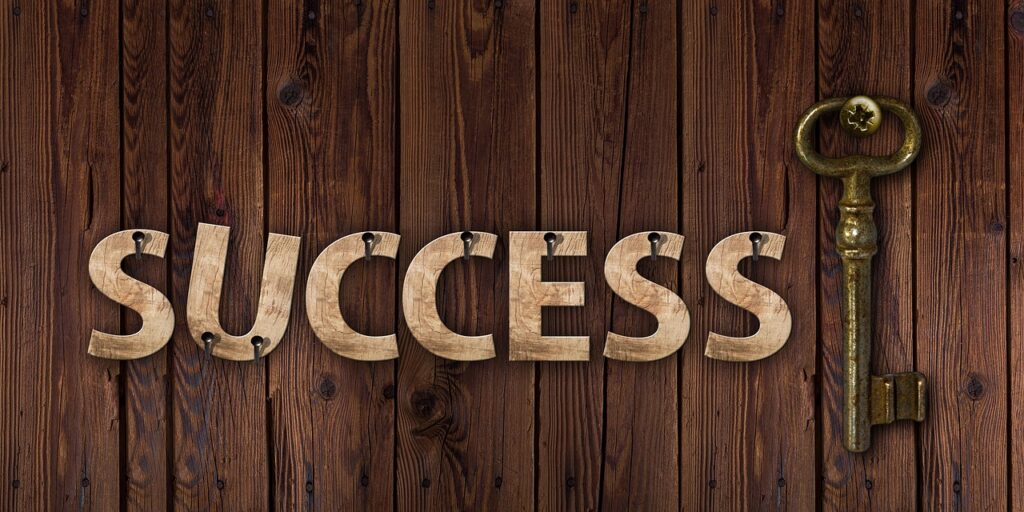 Wooden “SUCCESS” sign with an antique key next to it, symbolizing clarity, structure, and transformational resilience in achieving personal and professional growth.